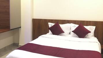 A hotel room with a bed, a ceiling fan, and a wooden headboard.
