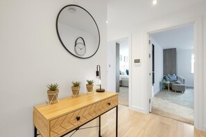 Enter a clean and bright living space with a console table and large mirror.