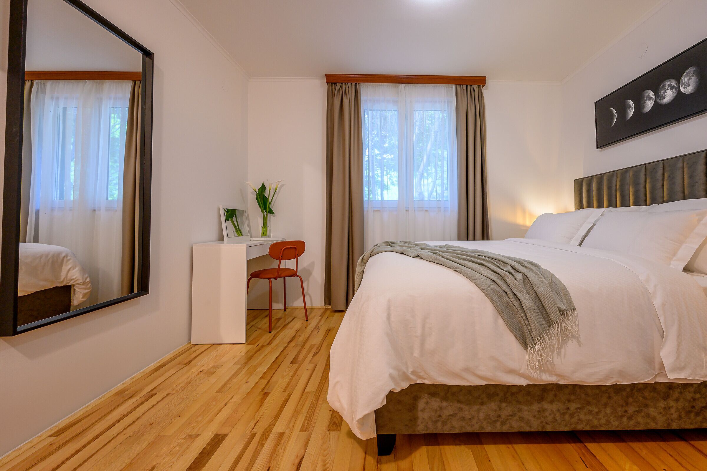 A bedroom with a bed, a desk, and a chair.