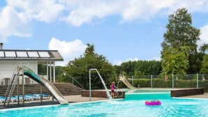 A swimming pool with two slides, a lifeguard chair, and lounge chairs. - 5 Person Holiday Park Home in Krusa (Krusaa)