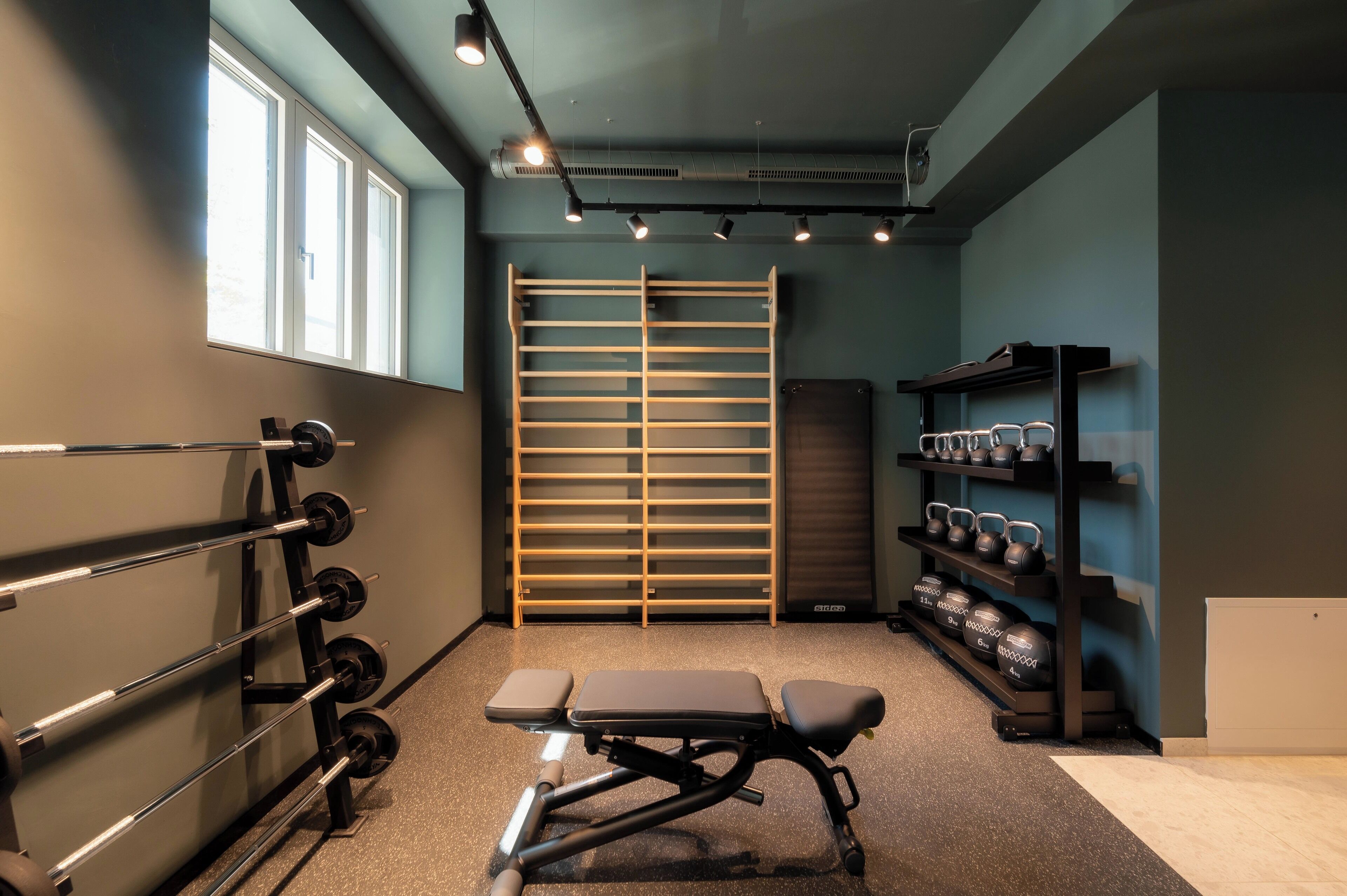 Een sportschool met een bankdrukapparaat, squatrek en kettlebells.