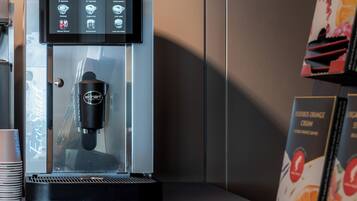 A coffee machine with a digital display, a glass enclosure, and a coffee cup holder.