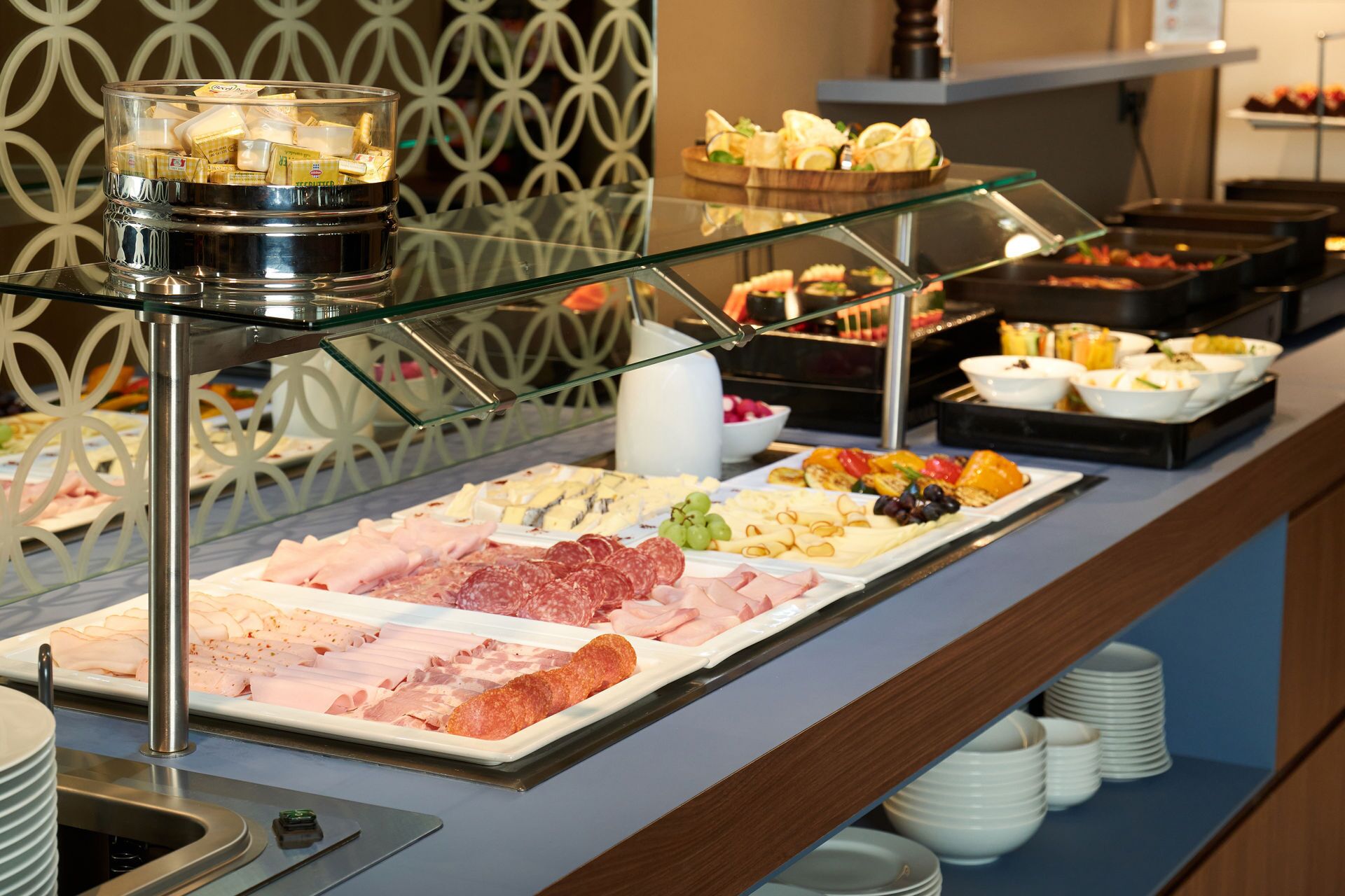 A buffet with various meats, cheeses, and fruits.