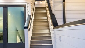 Una escalera de diseño moderno que conduce a una puerta de vidrio.