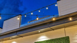 Un edificio moderno con techo plano, luces colgantes y una pared verde.