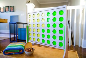 Ein Zimmer mit einer Wandtafel, einem blauen Tisch, einer farbenfrohen Decke und einer Schüssel mit Snacks.