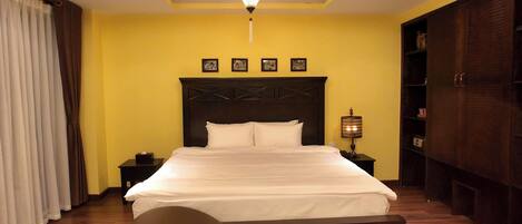 A neatly arranged bedroom with a bed, bedside tables, a lamp, and a wardrobe.