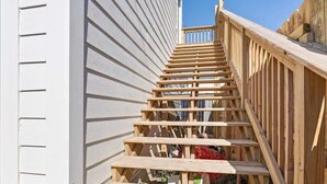 A wooden staircase leading up to a building with white siding. - Cityview Cottage (Indianapolis)