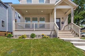 A two-story house with a front porch, a staircase, and a mailbox.