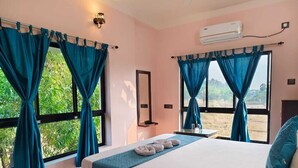 Een slaapkamer met een bed, gordijnen, een spiegel en een airconditioning.