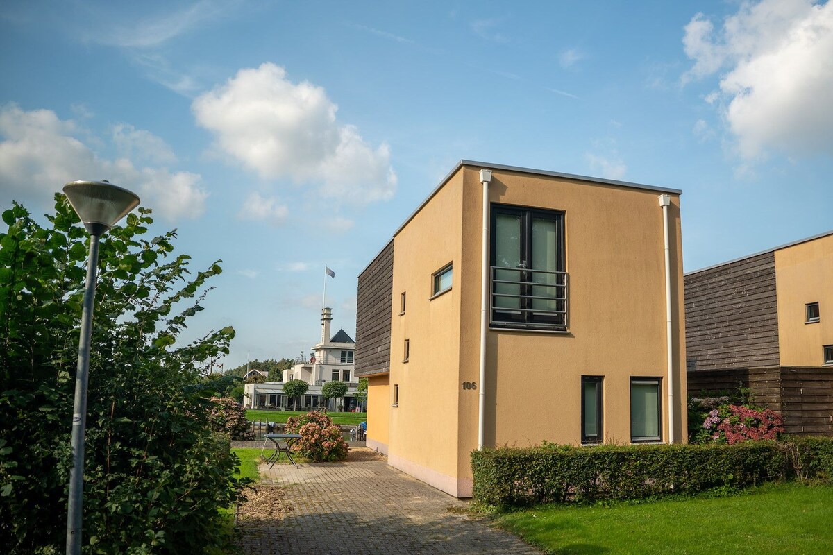 Un bâtiment moderne doté d’un toit plat, d’une grande fenêtre et d’un petit balcon.