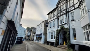 A narrow street lined with traditional half-timbered buildings, some with visible storefronts and signage. - Cosy Cottage for two in the Centre of Sedbergh (Sedbergh)