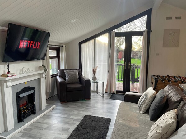 Cabin | Living area | Fireplace - 3 Bedroom Lodge - Pets, Parking, Wifi, Pool Access (Cirencester)