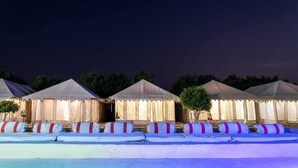 A row of tents with a flat roof, arranged in a line with a paved walkway in front. - Desert Fortune Resort (Jaisalmer)