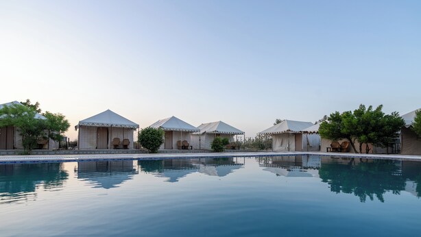 A pool area with several tents and a clear sky. - Desert Fortune Resort (Jaisalmer)