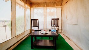 A tented room with two wooden chairs, a table, and a green carpet. - Desert Fortune Resort (Jaisalmer)