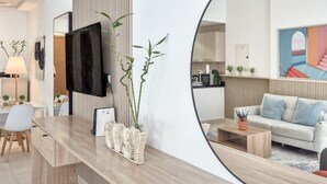 A modern living room with a large mirror, a flat-screen TV, a sofa, and a coffee table. - Cozy Golfside Studio (Abu Dhabi)