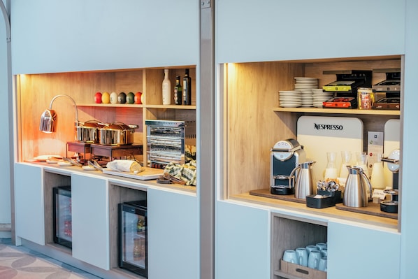 A coffee station with espresso machines, coffee cups, and a variety of coffee beans. - Hotel Cetina Casa de Aguilar (Córdoba)