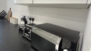 Eine moderne Küche mit schwarzem Arbeitsplatz, einer Kaffeemaschine und einem Toaster.