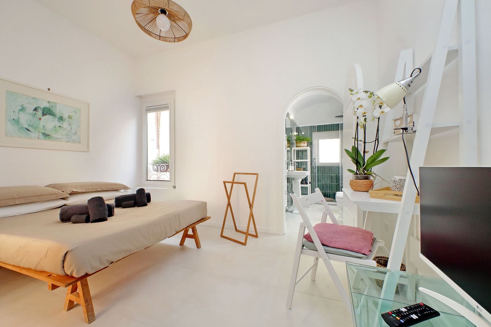 Une chambre moderne avec un lit, une table de chevet et un bureau avec un ordinateur.