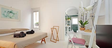 Une chambre moderne avec un lit, une table de chevet et un bureau avec un ordinateur.