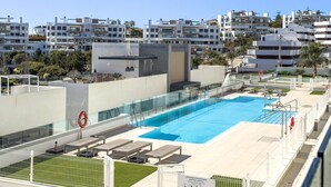 A rooftop swimming pool with a glass barrier, sun loungers, and a lifebuoy. - Modern apartment with terrace, pool, and Wi-Fi in Estepona (Estepona)