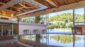 A dining area with a view of a swimming pool and trees. - Julia Hotel (Kassandra)