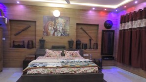 Ein Schlafzimmer mit Bett, Deckenventilator, Wanduhr und einem Gemälde.