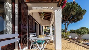 An outdoor patio with a table and chairs, a hanging planter, and a view of the surrounding area. - Roseus Villa, Galé, Algarve (Guia)