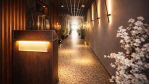 A hallway with wooden paneling, a marble accent wall, and a floral arrangement. - YOU Cairo Nile View Hotel (Cairo)