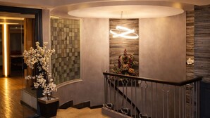 A modern interior with a staircase, a decorative wall with a geometric pattern, and a potted plant. - YOU Cairo Nile View Hotel (Cairo)
