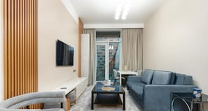 Deluxe appartement, 1 slaapkamer, uitzicht op stad | Woonruimte | Een 55-inch smart-tv met kabelzenders