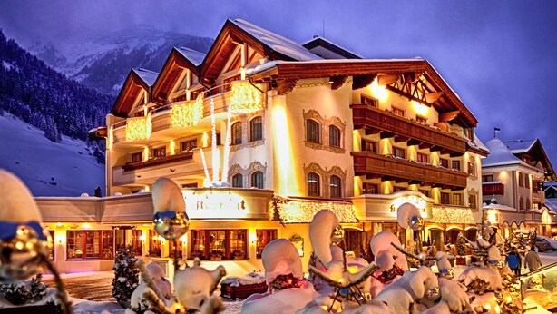 A large, multi-story hotel with balconies and a snow-covered landscape in the background. - Hotel Salnerhof Ischgl (Ischgl)