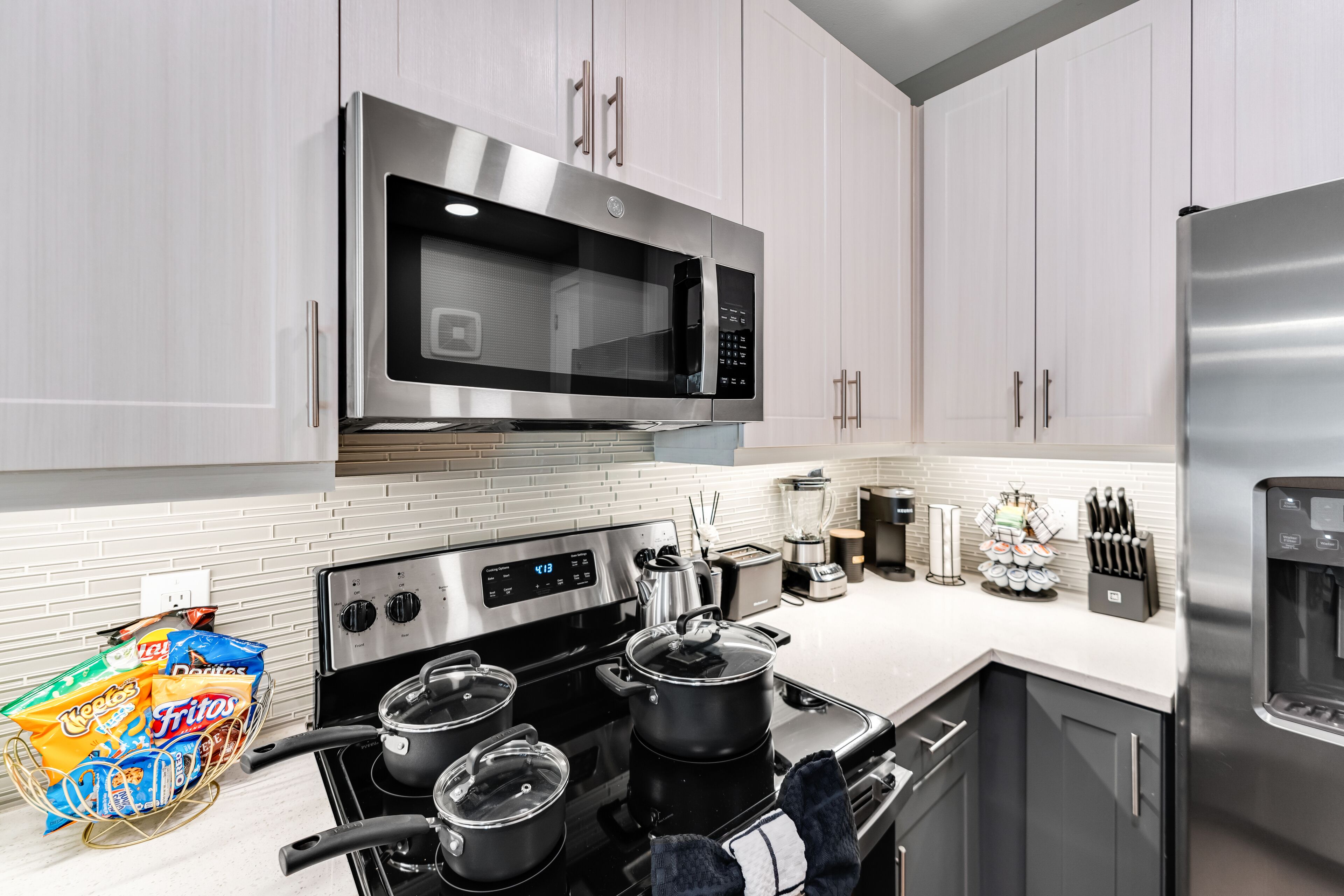 A modern kitchen with stainless steel appliances, a stove, microwave, and a refrigerator.