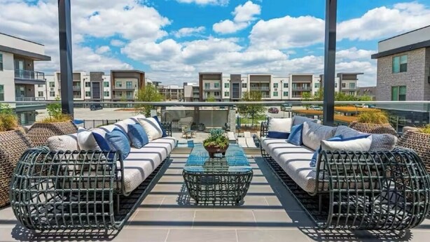 A rooftop terrace with outdoor seating, a central table, and a view of modern buildings. - Charming 1-bedroom apartment in Fort Worth with WiFi, AC, fitness room (Fort Worth)