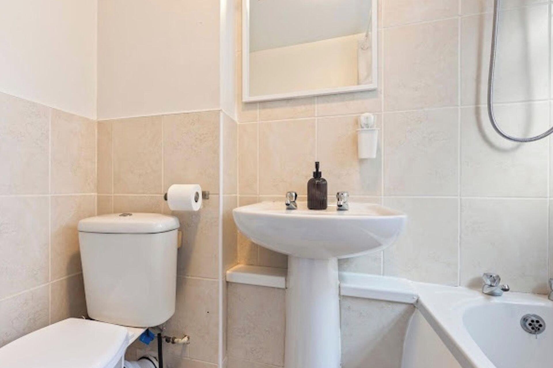 A bathroom with a toilet, sink, and bathtub.