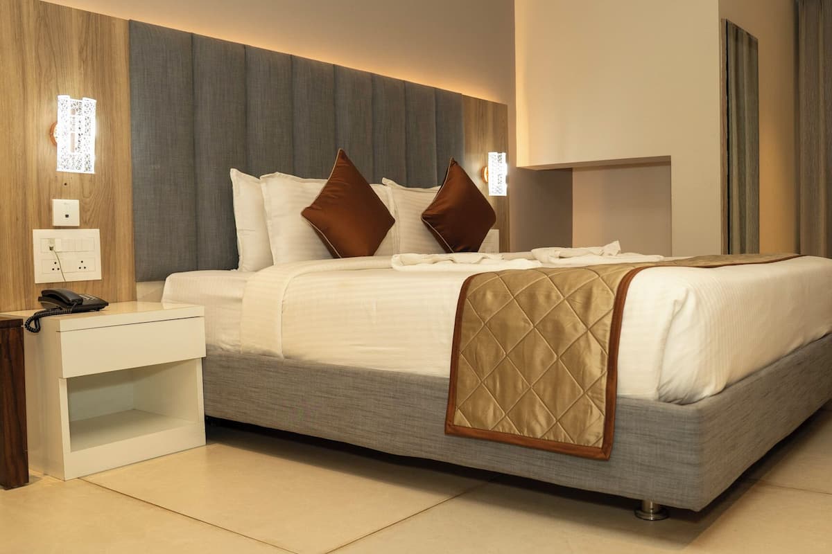 A neatly arranged hotel room with a bed, bedside table, and a telephone.