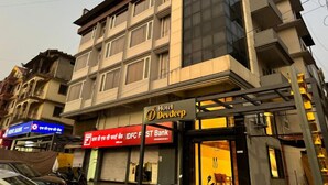 A multi-story building with a sign for Hotel Devdeep.