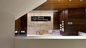 A hotel reception desk with a sign reading "Hotel Devdeep."