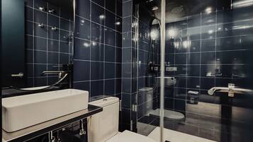 Een douche, handdoeken, zeep, toiletpapier