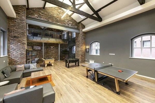 A spacious loft with exposed brick walls, a ping pong table, and a foosball table. - For Students Only - Sheffield 3 in Sheffield (Sheffield)