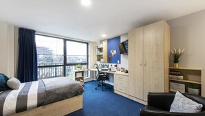 Une chambre moderne avec un grand lit, un bureau et une armoire.