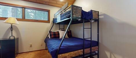 Habitación con literas, ventana, lámpara y escritorio.
