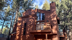A cabin with a balcony, large windows, and a wooden exterior. - Woodlands #40 3 Bedroom Condo (Mammoth Lakes)