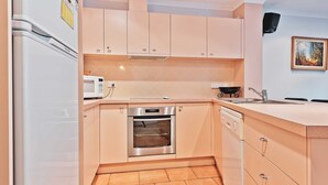 Una cocina compacta equipada con microondas, horno y lavavajillas.