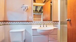 Een badkamer met toilet, wastafel en spiegel.