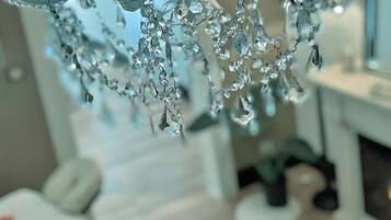 Un lustre orné de nombreux éléments de cristal, suspendu à un plafond blanc.