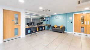 Un espace d’accueil comprenant un comptoir, des ordinateurs, un canapé et un panneau mural sur lequel on peut lire : « Bienvenue à St. Davids. »