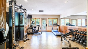 Une salle de sport équipée de machines d’exercice, de tapis de course et d’haltères.