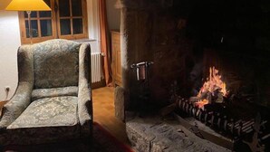 A cozy room with a fireplace, a patterned armchair, and a lamp. - La chasse - a beautiful cottage between coast and countryside (Anglesqueville-la-Bras-Long)